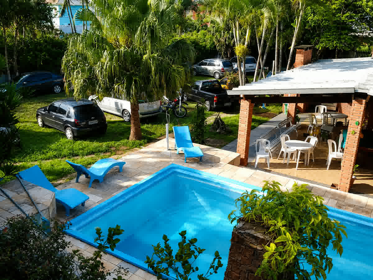 Área da piscina com espreguiçadeiras e jardim